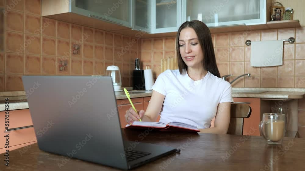 Digital self education online. Smiling girl using laptop at home, making notes and learning foreign languages Digital self education online. Smiling girl using laptop at home, making notes and learning foreign languages