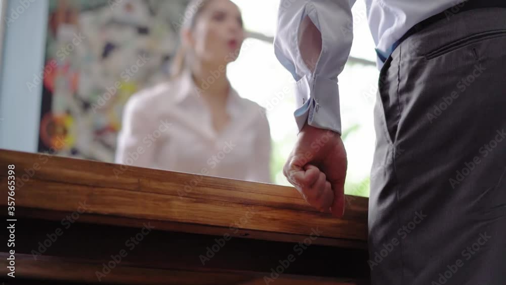Business woman screaming at elevated tones at an employee or colleague standing at a table. Low corner shot. Psychological state concept. Business concept. Prores 422. Business woman screaming at elevated tones at an employee or colleague standing at a table. Low corner shot. Psychological state concept. Business concept. Prores 422.