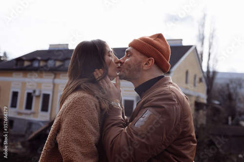 in love stylish young couple kissing in the city. Fashion outdoor sensual romantic portrait of beautiful young couple hugs and kissing on the city. selective focus © Andriy Medvediuk