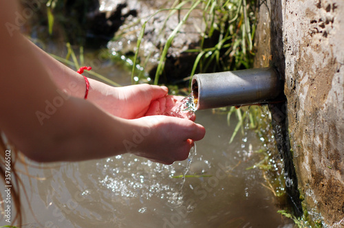 A girl collects water from a spring