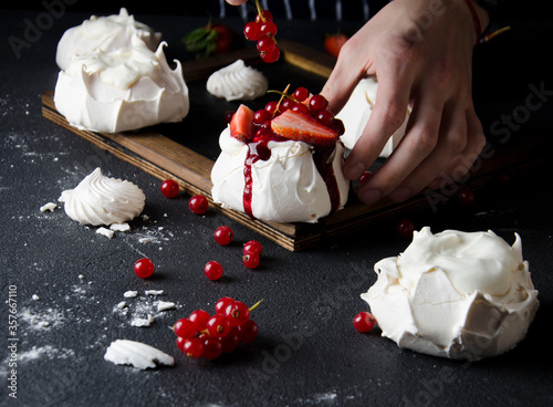 Delicious white meringue dessert Pavlova decorated by red berries