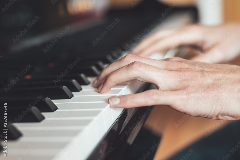 Obraz premium Playing piano at home, high angle view, blurry background.