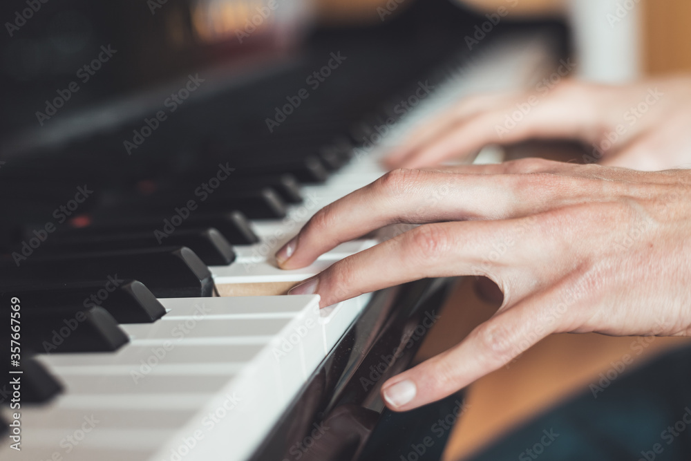 Playing piano at home, high angle view, blurry background.