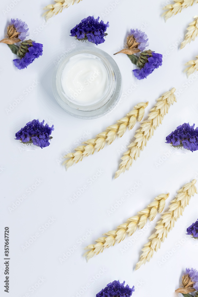 Cosmetic cream with blossom,wheat, top view isolated on white background. Luxurious cosmetics and makeup concept.Open Jar of Face cream. Natural organic cosmetic facial with herbal ingredients. Cosmetic cream with blossom,wheat, top view isolated on white background. Luxurious cosmetics and makeup concept.Open Jar of Face cream. Natural organic cosmetic facial with herbal ingredients.