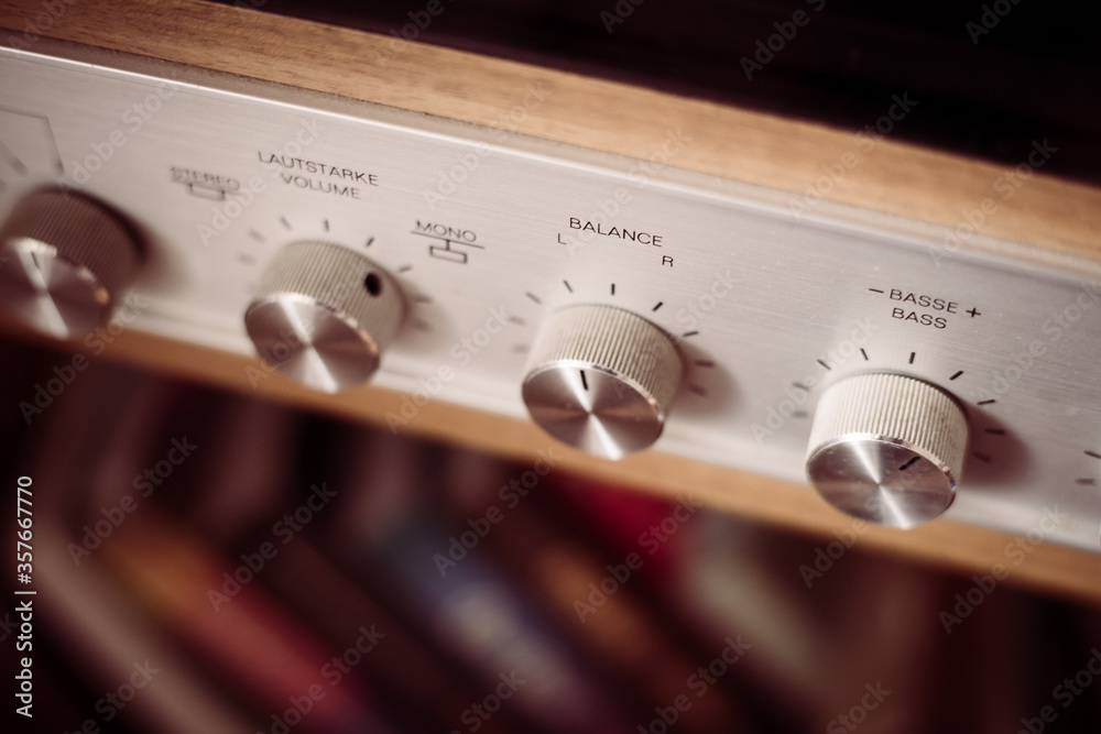 Obraz premium Silver wooden vintage amplifier: Close up of control knobs