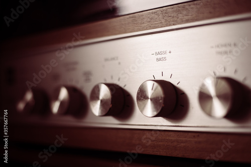 Silver wooden vintage amplifier: Close up of control knobs photo