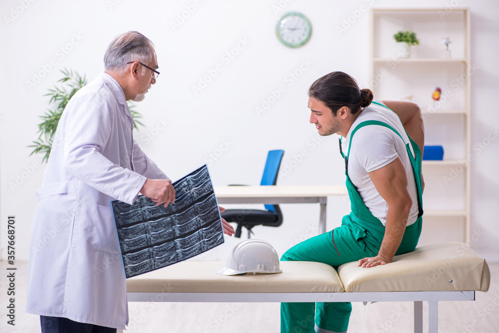 Obraz premium Young male contractor visiting old doctor