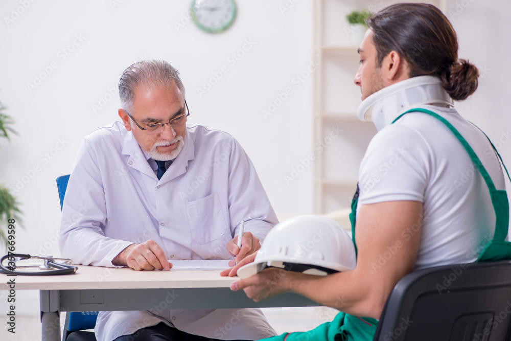 Young male contractor visiting old doctor