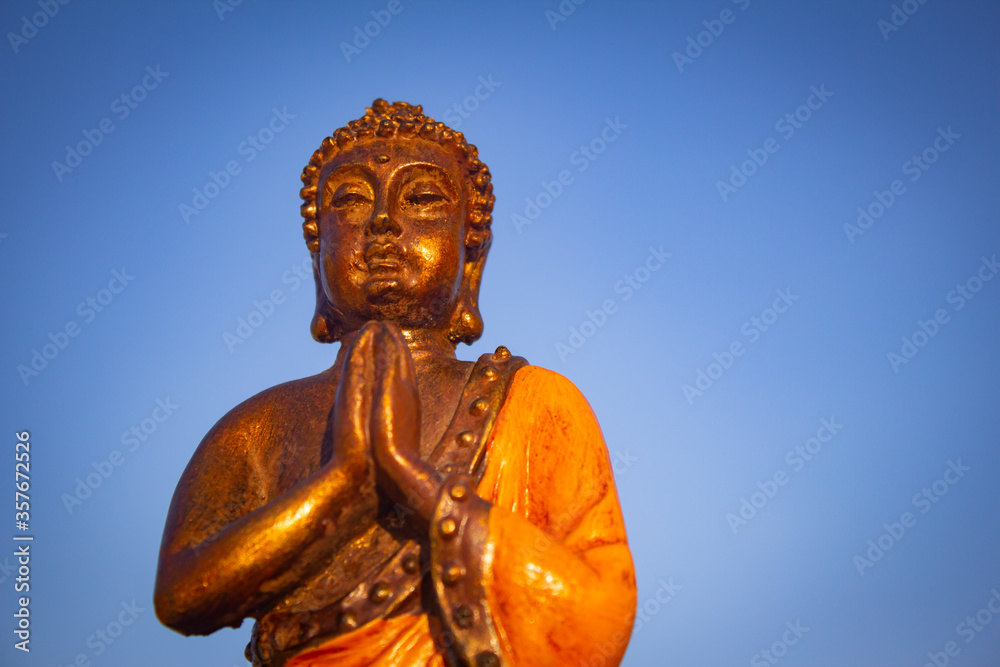 Closeup view of Buddha against blue sky background