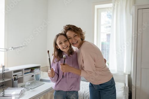 Portrait of smiling Caucasian mother and teenage daughter have fun in bedroom together, happy overjoyed loving mom and teen girl child enjoy family leisure weekend at home, bonding concept