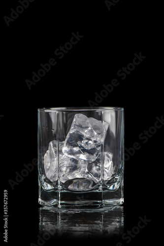 Glass for alcoholic drinks with cun ice on black