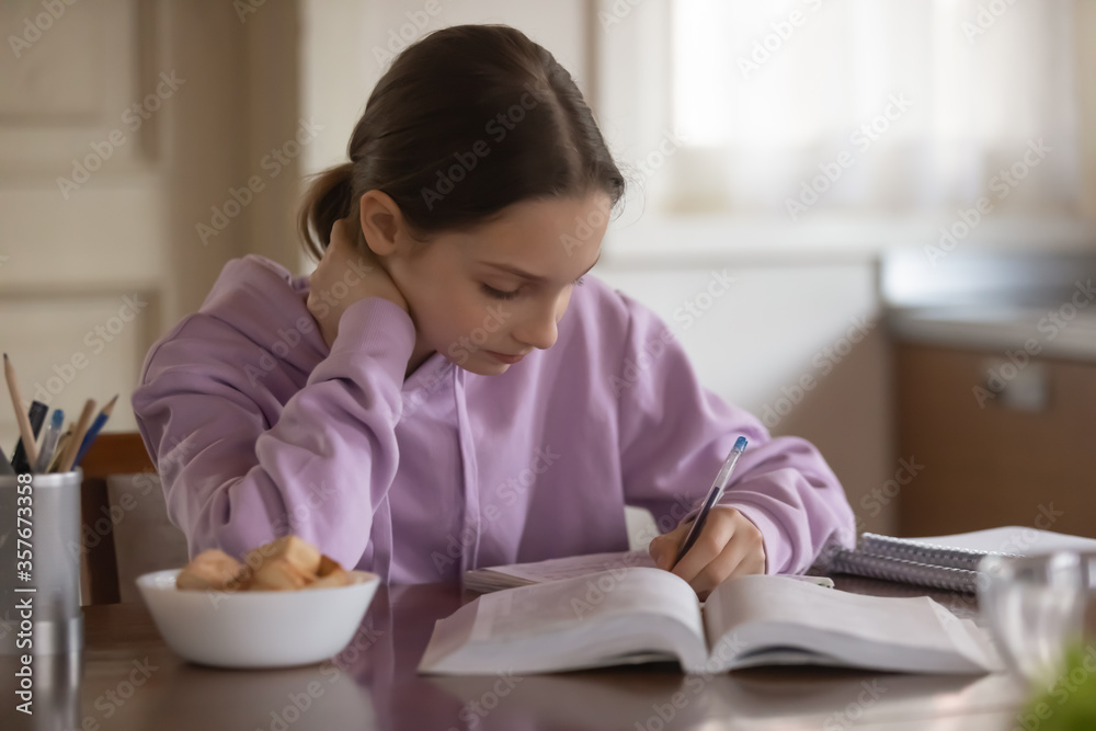 Focused teenage schoolgirl sit at table handwrite in notebook prepare homework alone at home, concentrated teen girl pupil study learning, write make notes, do assignment, education concept Focused teenage schoolgirl sit at table handwrite in notebook prepare homework alone at home, concentrated teen girl pupil study learning, write make notes, do assignment, education concept