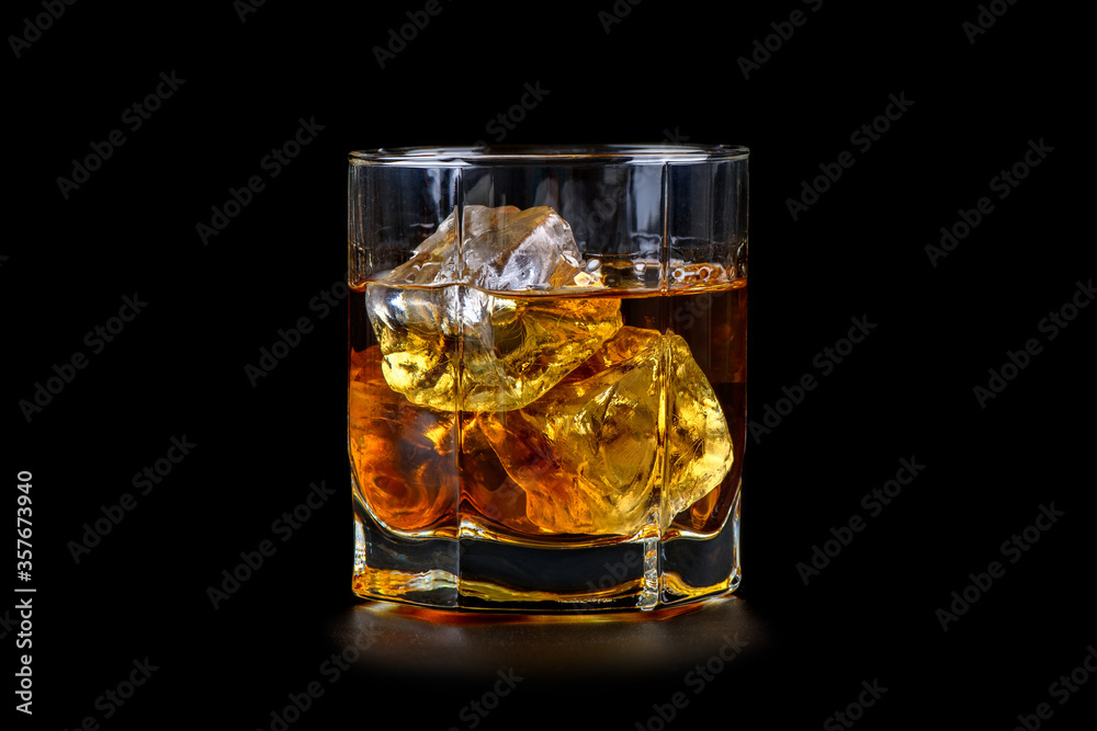 Glass of whiskey with cube ice on black background Glass of whiskey with cube ice on black background