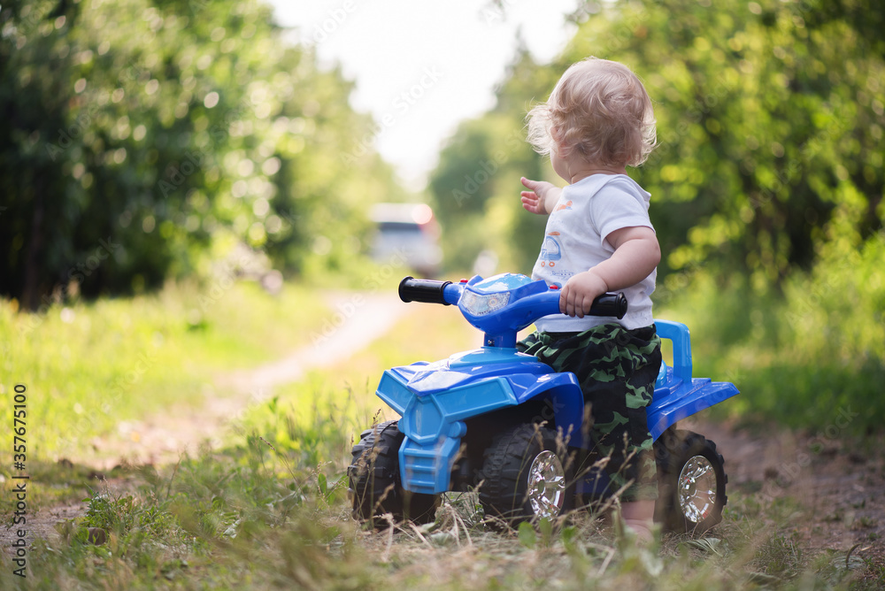 Baby boy is riding a toy car quad bike. Baby boy is riding a toy car quad bike.