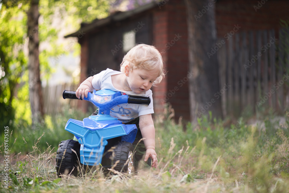 Baby boy is riding a toy car quad bike. Baby boy is riding a toy car quad bike.