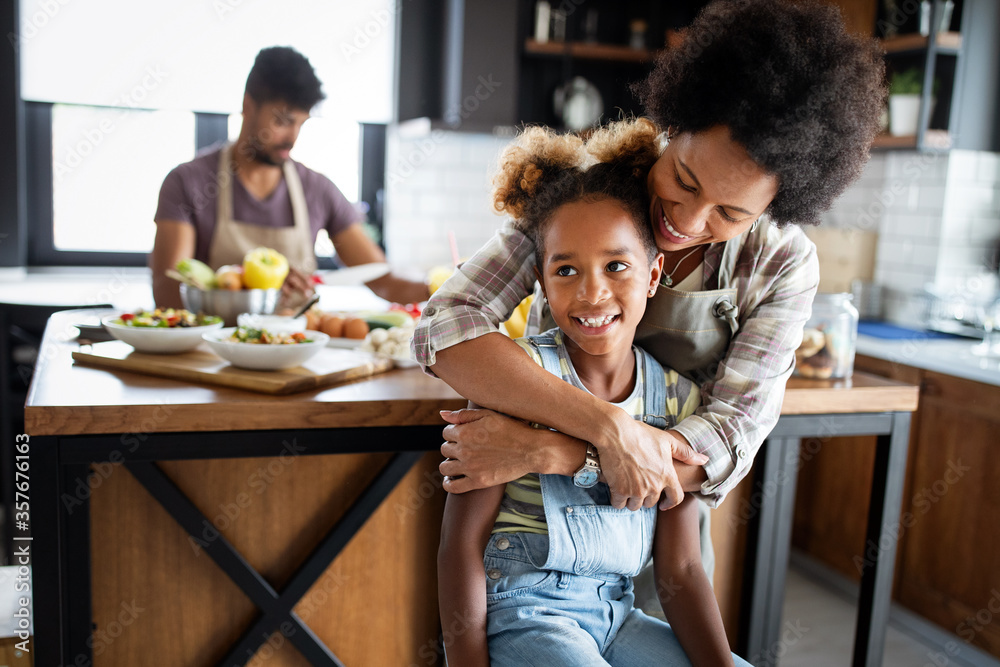 Obraz premium Happy family preparing healthy food in kitchen together