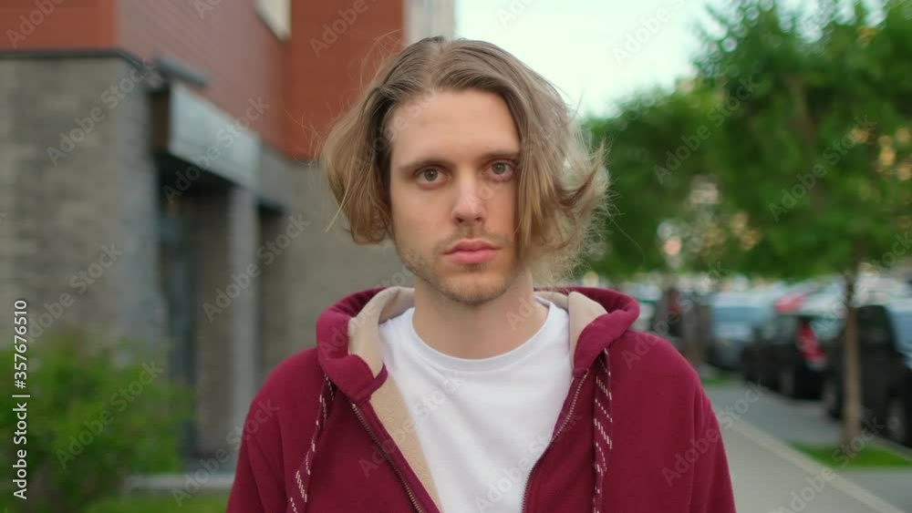 Close-up portrait of handsome young hipster man, guy standing outdoors street alone serious sad looking at camera, Beautiful people, student city lifestyle and urban emotions youth concept 4 K slow-mo Close-up portrait of handsome young hipster man, guy standing outdoors street alone serious sad looking at camera, Beautiful people, student city lifestyle and urban emotions youth concept 4 K slow-mo