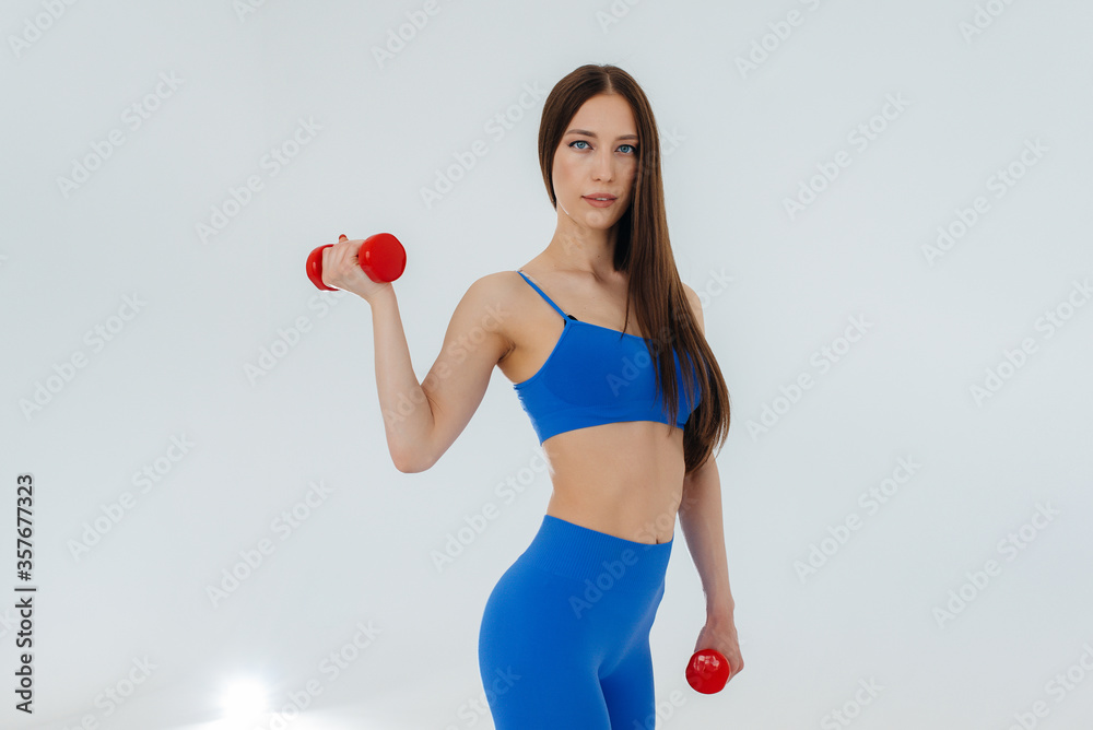 Sexy young girl performs sports exercises on a white background. Fitness, healthy lifestyle Sexy young girl performs sports exercises on a white background. Fitness, healthy lifestyle