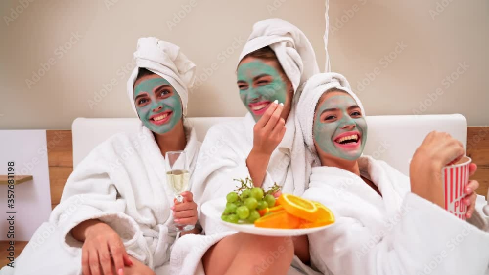 Girls watching movie in bed and laughing. Girls watching movie in bed and laughing.