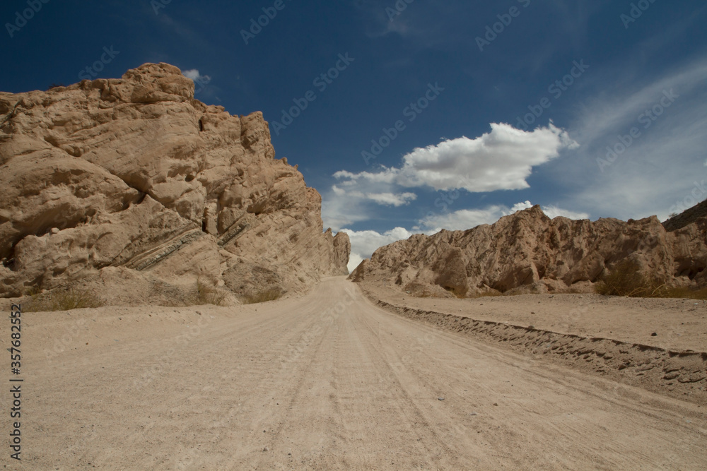 Traveling along Route 40. Dirt road across the arid desert and sandstone, in Quebrada de las Flechas, Salta, Argentina. Traveling along Route 40. Dirt road across the arid desert and sandstone, in Quebrada de las Flechas, Salta, Argentina.