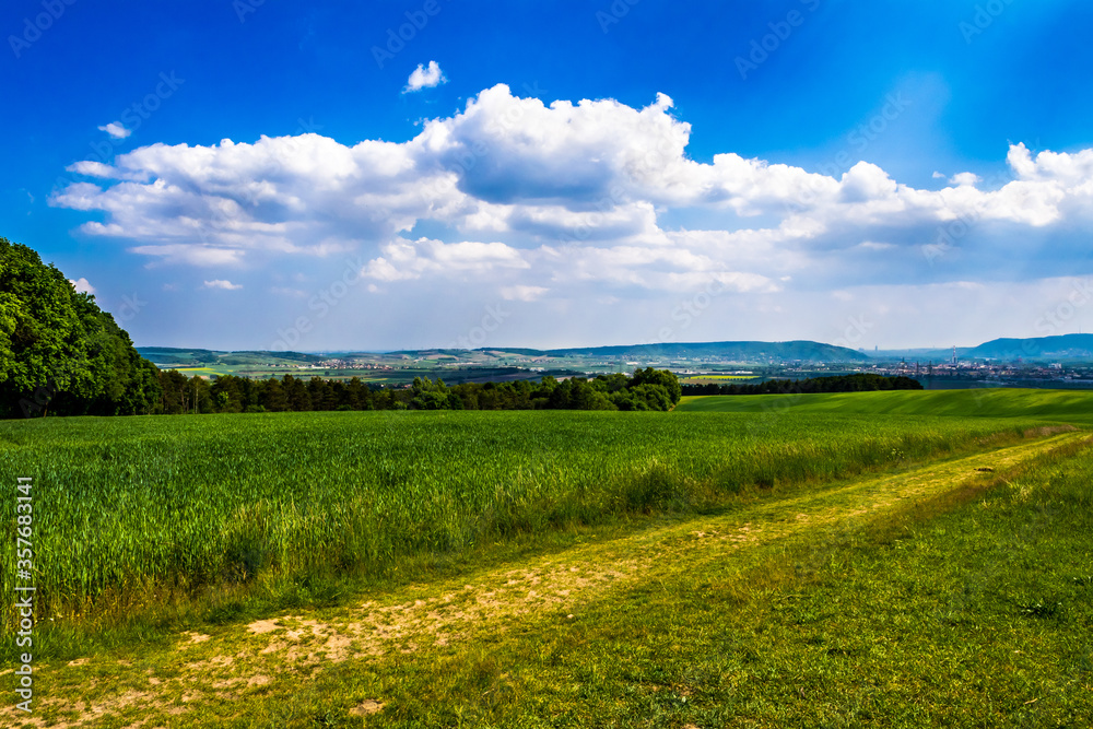 Rural Landscape With Sunlit Clouds In Front Of The Skyline Of Vienna In Austria
