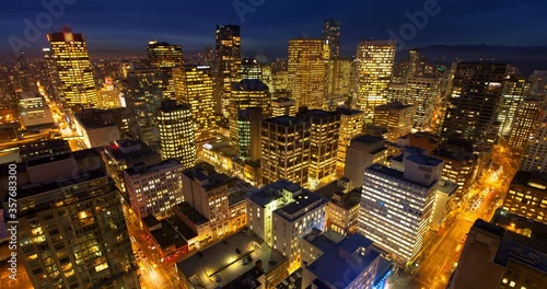 Lockdown time lapse shot of illuminated buildings and street in city at night - Vancouver, Canada photo