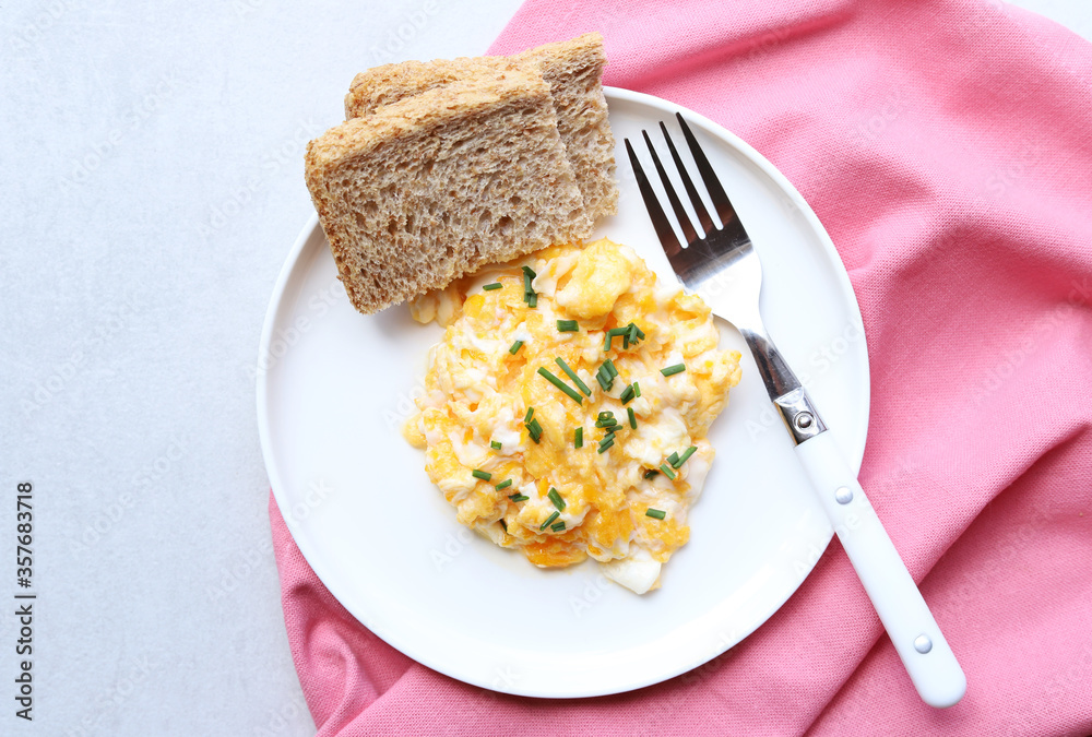 Scrambled eggs on a white plate. Healthy food or breakfast concept.