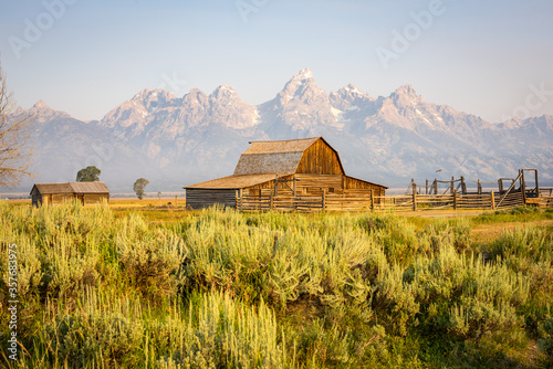 Grand Teton mountain range behind a rustic wooden barn along the famous & historic Mormon Row in Grand Teton National Park, Wyoming, United States of America