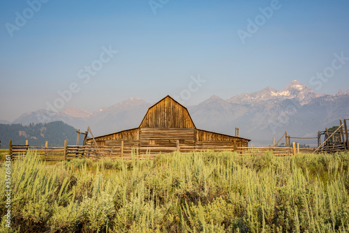 Grand Teton mountain range behind a rustic wooden barn along the famous & historic Mormon Row in Grand Teton National Park, Wyoming, United States of America