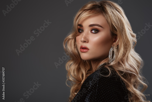 Beautiful model  woman with hollywood waves hairstyle  smokey eyes makeup  wearing trendy earrings with rhinestones. Close up studio portrait. Copy  empty space for text