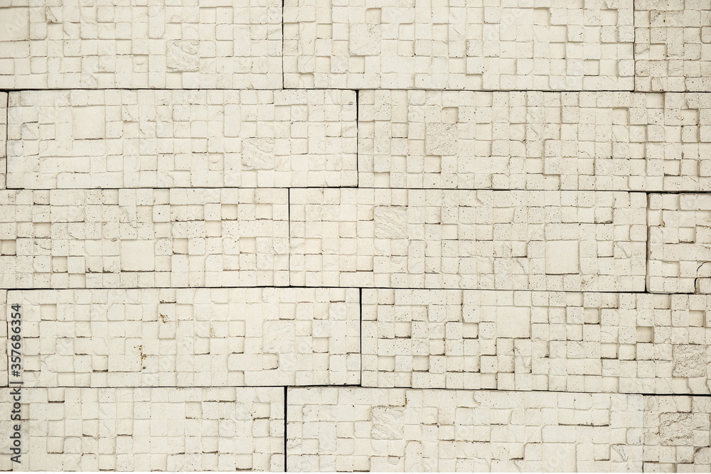 Obraz premium decorative yellow and white brick wall, plaster and light background, building wall