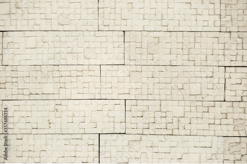 decorative yellow and white brick wall, plaster and light background, building wall