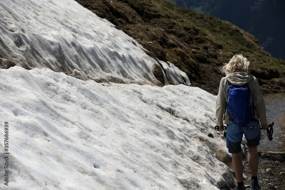 Wanderin beim überqueren eines Schneefeldes in den Bergen