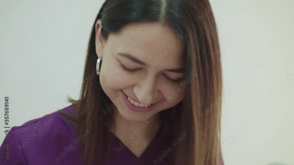 Portrait of happy beautician in uniform smiling during treatment Portrait of happy beautician in uniform smiling during treatment