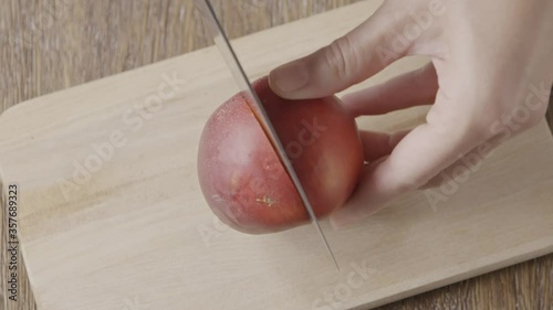 Slow video process of dividing fresh juicy nectarine on two halv photo