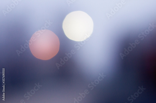 Colorful blue foggy bokeh background, pink and white round blurred spots.