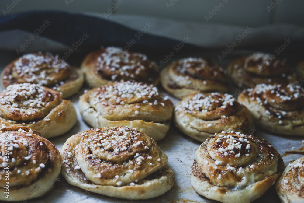 Batch of freshly baked homemade Swedish style cinnamon rolls / buns with pearl sugar. Slightly increased contrast, vintage style photo -Image