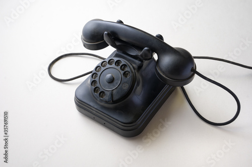 old 1950s bakelite telephone of 3/4 left on white background photo