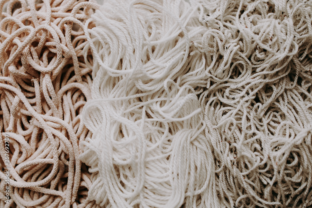 Three different tangled macrame cord heap on grey background Three different tangled macrame cord heap on grey background