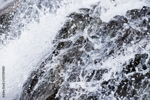 Close up of a mountain waterfall and water bumping into the rocks. © PhotoHunter