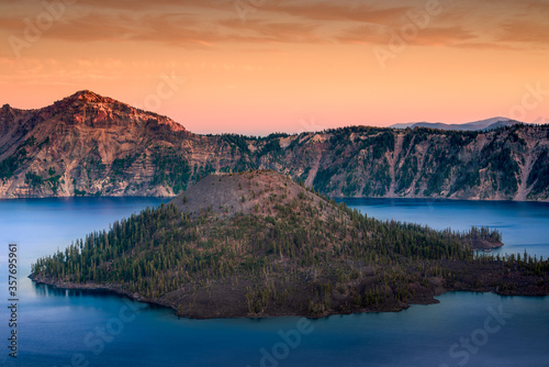 beautiful sunset at crater lake in Oregon with blue water and tree