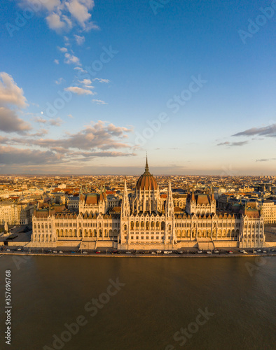 Aerial drone view of Hungarian Parliament facade by danube river in Budapest sunset hour