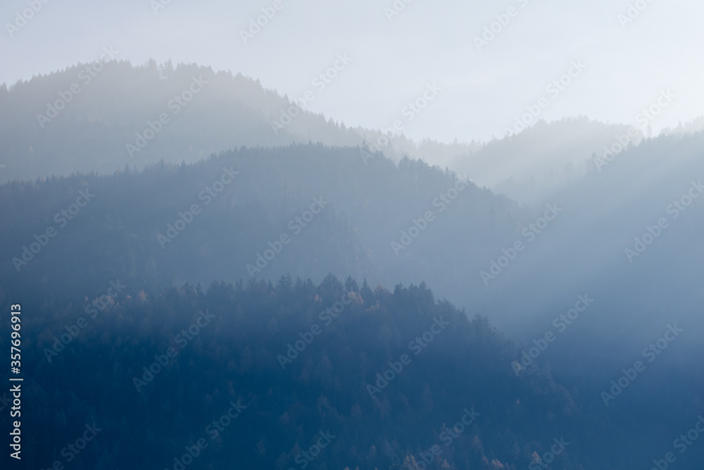 Mountain landscape with forest hills on a background of foggy sky, Kufstein Austria.