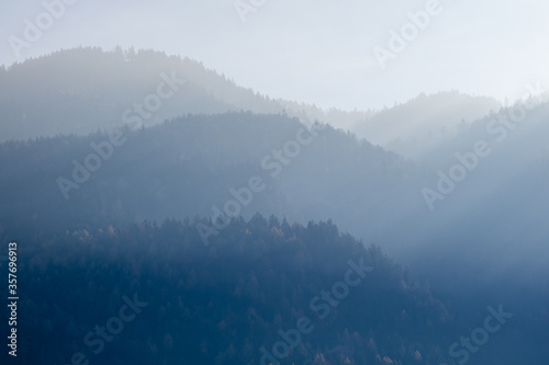 Mountain landscape with forest hills on a background of foggy sky, Kufstein Austria.