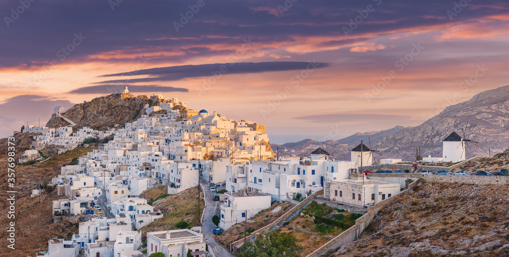 The chora - capital with traditional white houses of Serifos island Aegean Cyclades Greece against a dramatic sky on sunset on summer - obrazy, fototapety, plakaty 