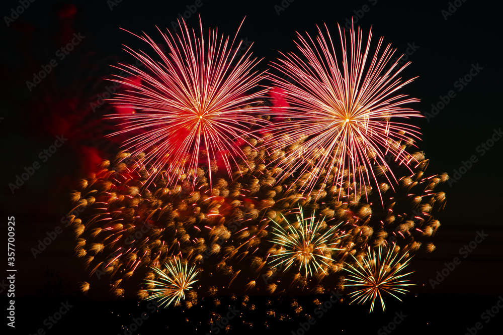 Festive fireworks in the night sky. Bright multi-colored salute on a black background. Place for text.