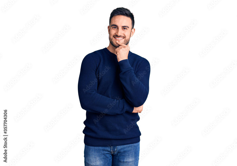 Young handsome man wearing casual clothes looking confident at the camera with smile with crossed arms and hand raised on chin. thinking positive. Young handsome man wearing casual clothes looking confident at the camera with smile with crossed arms and hand raised on chin. thinking positive.