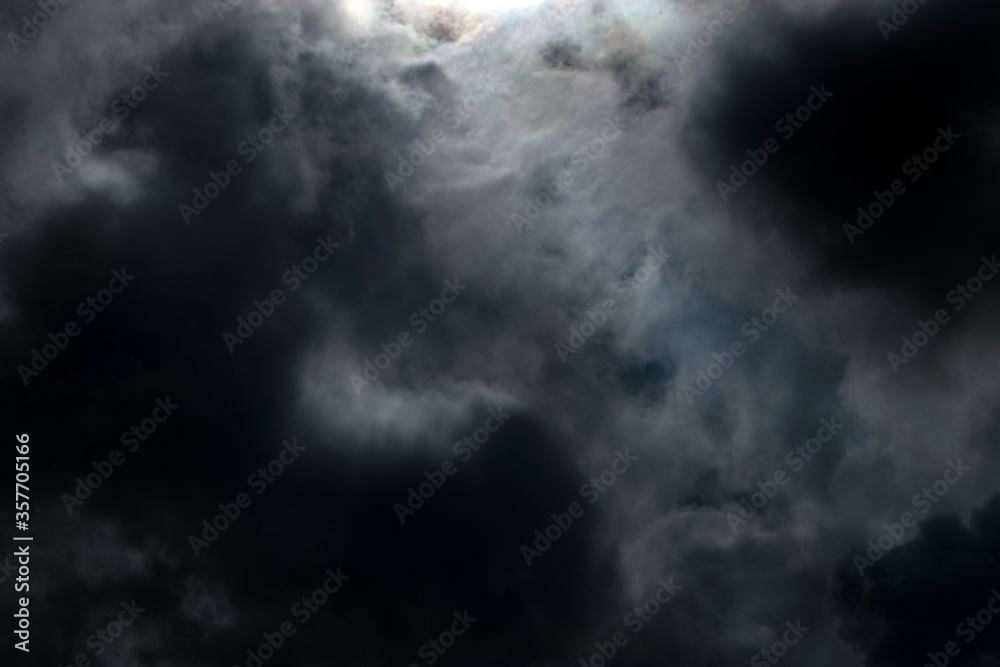Dramatic sky with sun and dark clouds