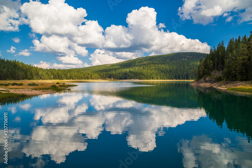 Fototapeta Naklejka Na Ścianę i Meble -  Lake in the mountains with blue sky and clouds. black lake in Montenegro.