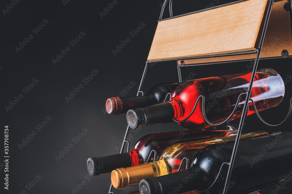 Naklejka premium Holder with bottles of wine on dark background